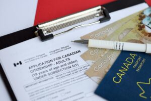 Application for Canadian citizenship for adults on table with pen, passport and dollar bills